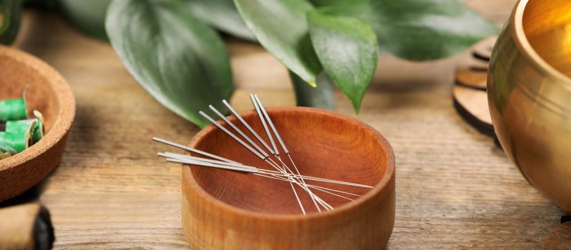 Needles over a wooden bowl for acupuncture in Calgary.