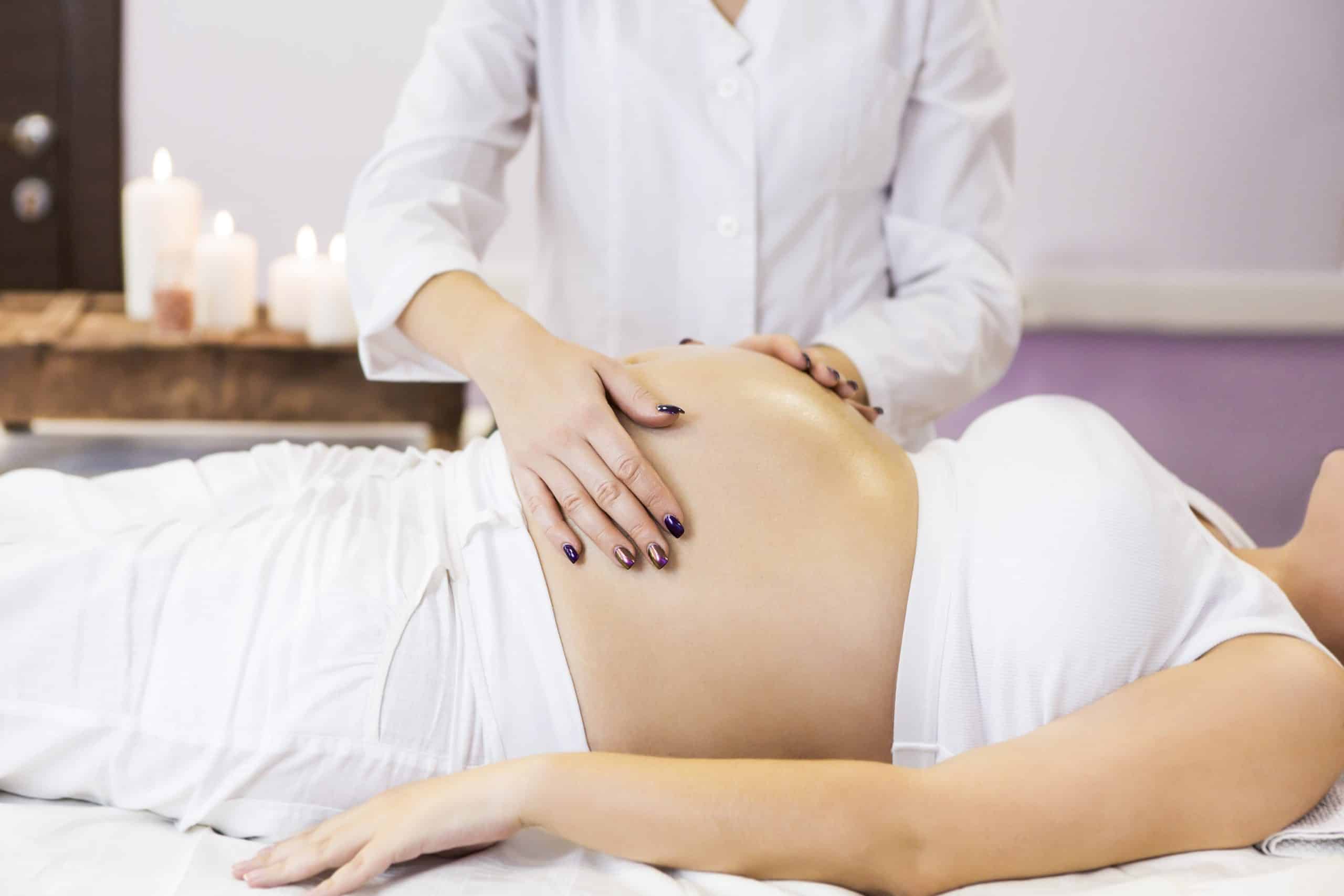 Young pregnant woman have massage treatment at spa salon