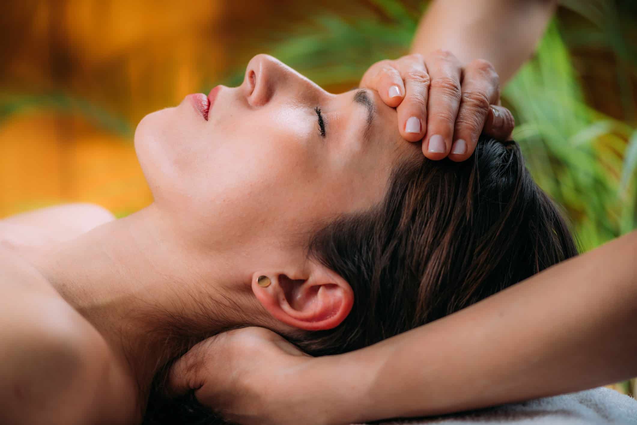 Craniosacral therapy massage. Therapist massaging woman’s forehead.